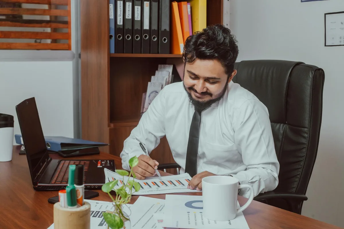 رائد أعمال إماراتي يستعرض متطلبات الرخصة التجارية الإلكترونية في دبي على حاسوبه