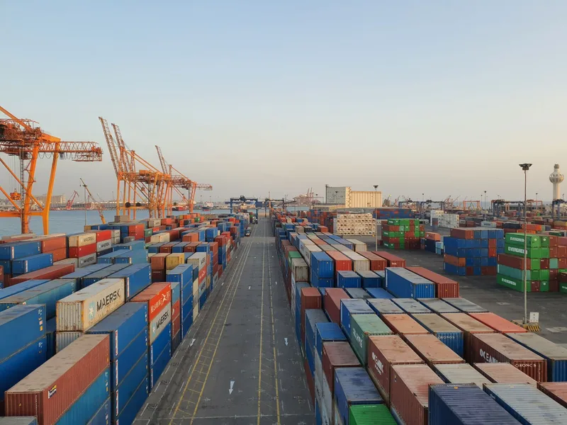 Cargo shipping containers at a UAE port representing cross-border import from Malaysia