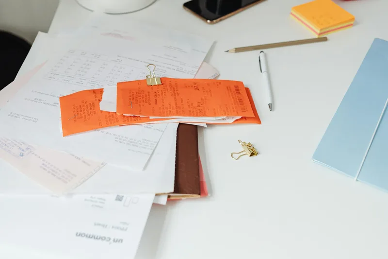 Ecommerce seller organizing business receipts and expense records at a desk